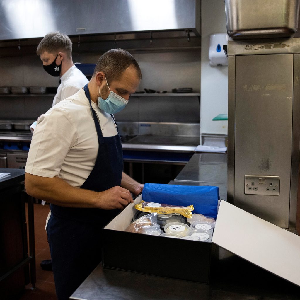 James Knappett, founder and head chef of 'Home', the first at-home fine dining experience, packs food into a box destined for customers in London, Britain, November 18, 2020. Picture taken November 18, 2020. REUTERS/Simon Dawson - RC2BAK9QVT5C