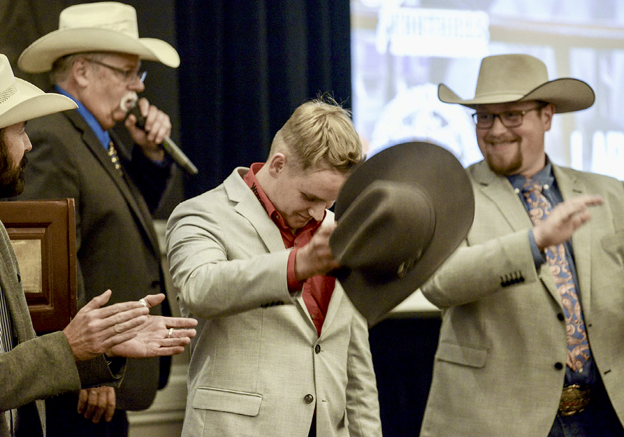 Lars Deleeuw, 19, the self-taught rookie auctioneer, tips his hat after his history-making win as Rookie of the Year and Grand Champion at the 25th Canadian Livestock Auctioneer Championship. He is the first and youngest to win Rookie of the Year and Grand Champion.