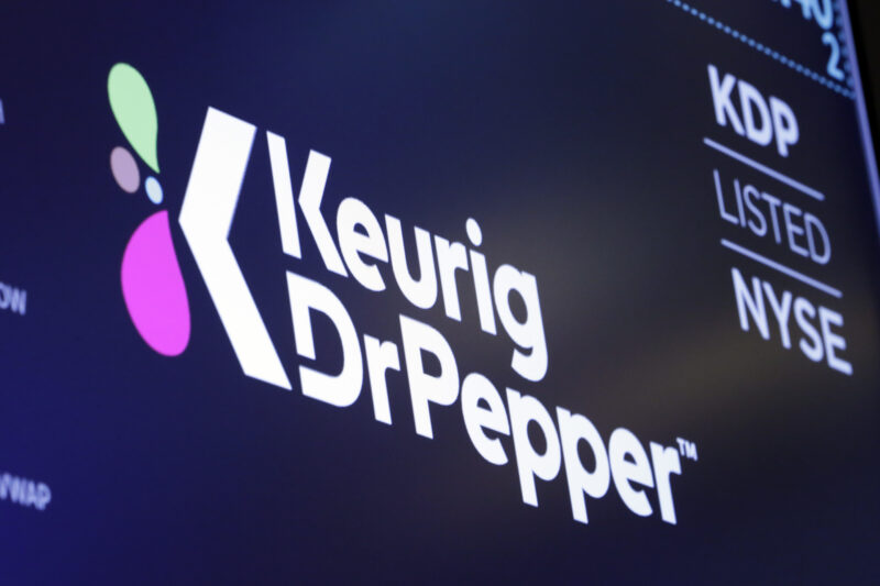 FILE - The new logo for Keurig Dr. Pepper appears above a trading post on the floor of the New York Stock Exchange, Thursday, July 12, 2018. (AP Photo/Richard Drew, File)