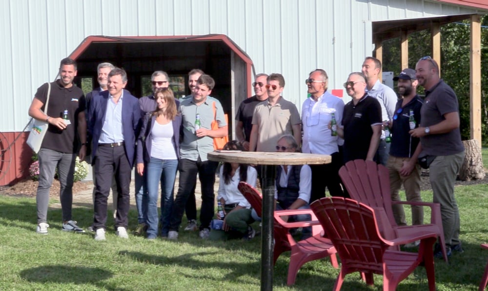 A group of attendees at the networking event pose for a ‘family photo’ outside the Business Lounge at Canada’s Outdoor Farm Show.