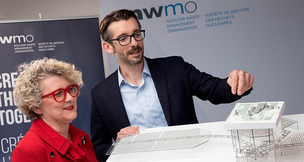 Laurie Swami, Nuclear Waste Management Organization (NWMO) president and CEO, left, looks over a model of Canada