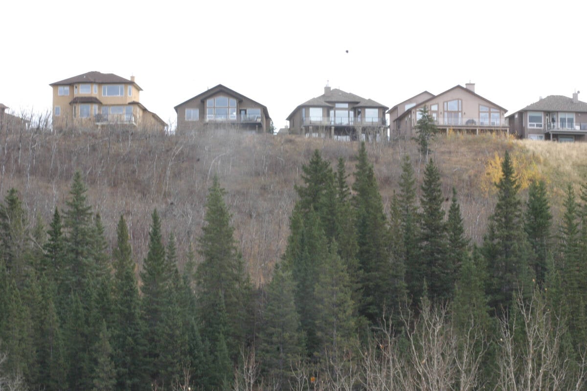Looking up at homes perched on a ridge with a scenic view of the valley below.