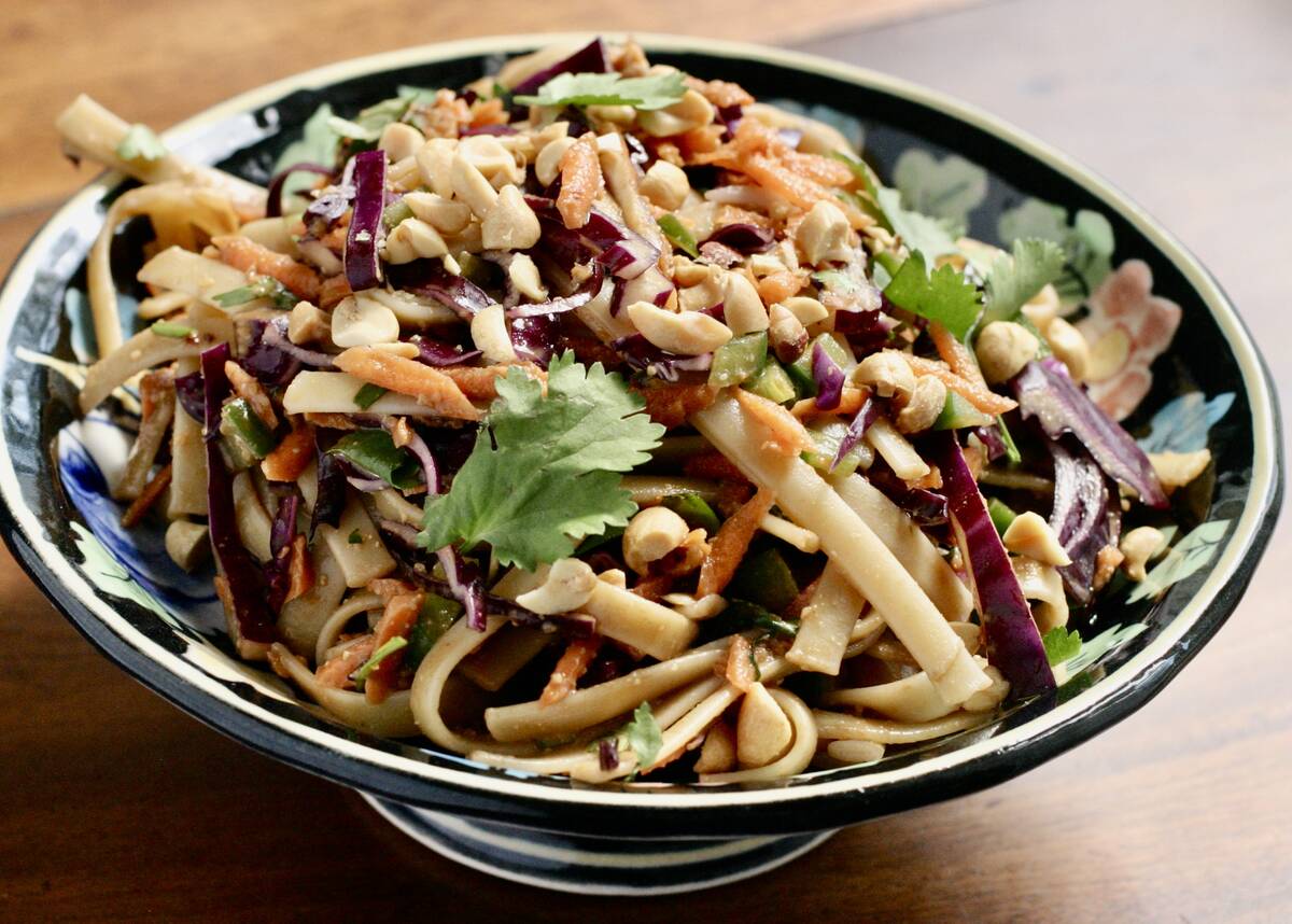 A pasta salad sits in a bowl on a table.