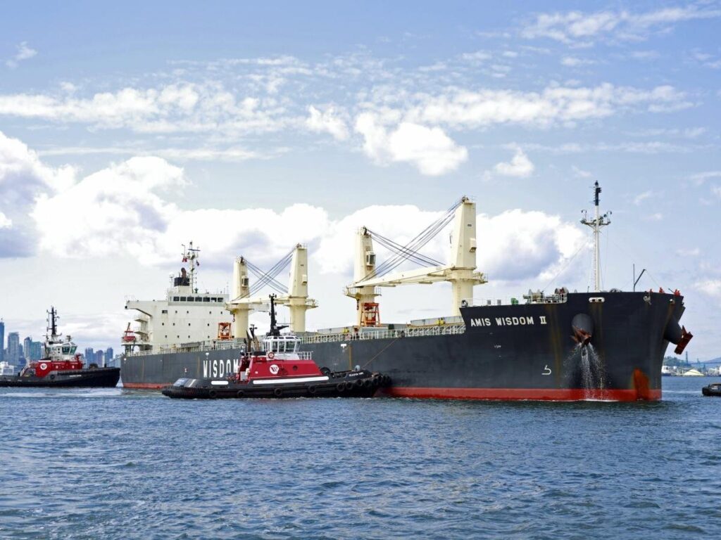 Tugboats position a bulk carrier ship in the Port of Vancouver.