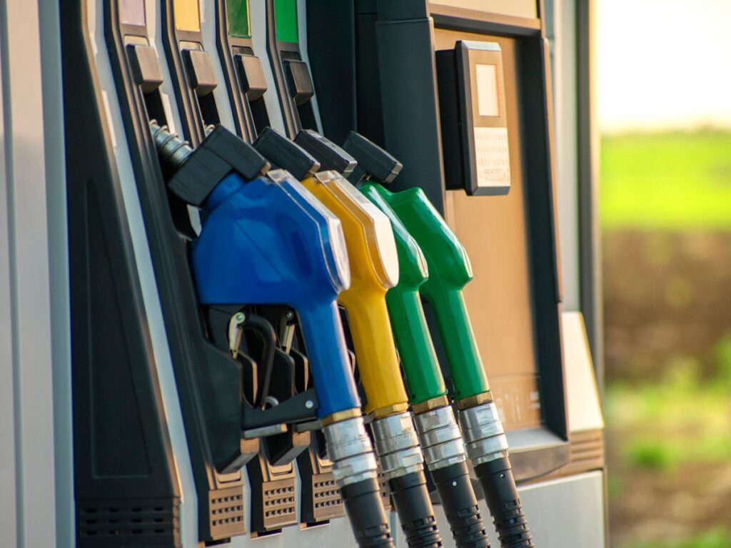Fuel guns at the fuel station and green field in the background.