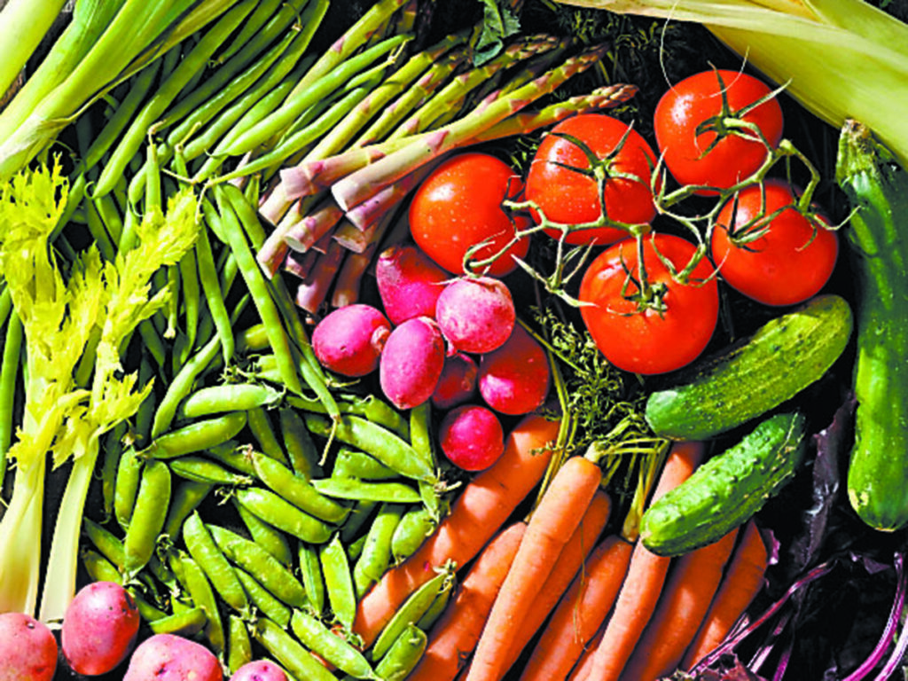 A colourful display of fresh vegetables including asparagus, beans, peas, potatoes, carrots, radishes, celery, cucumbers and tomatoes.