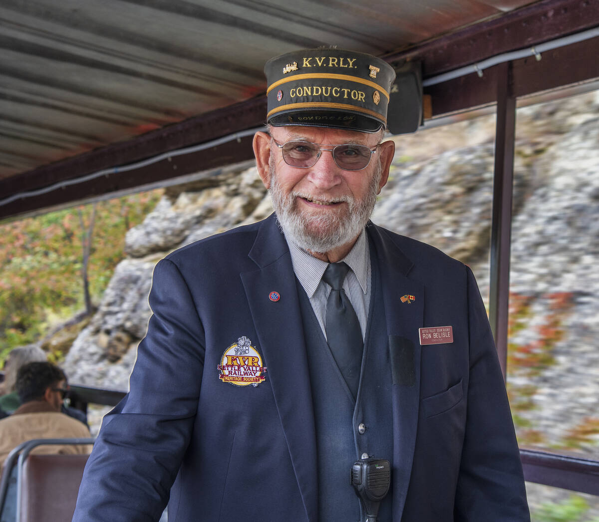 A conductor on the Kettle Valley Railway poses for a photo in uniform.