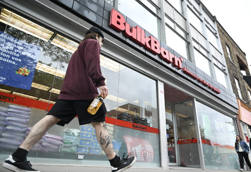 People walk by a Bulk Barn store in Montreal, Sunday, June 1, 2025. New French-language rules took effect in Quebec on Sunday requiring French to be the dominant language on store signs and imposing stricter guidelines for product packaging. THE CANADIAN PRESS/Graham Hughes