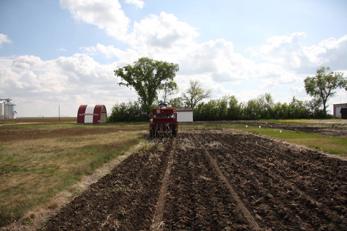 A person sits atop a crop plot seeder at the Ag-Quest crop plots at the Ag in Motion farm show site on May 23, 2025.