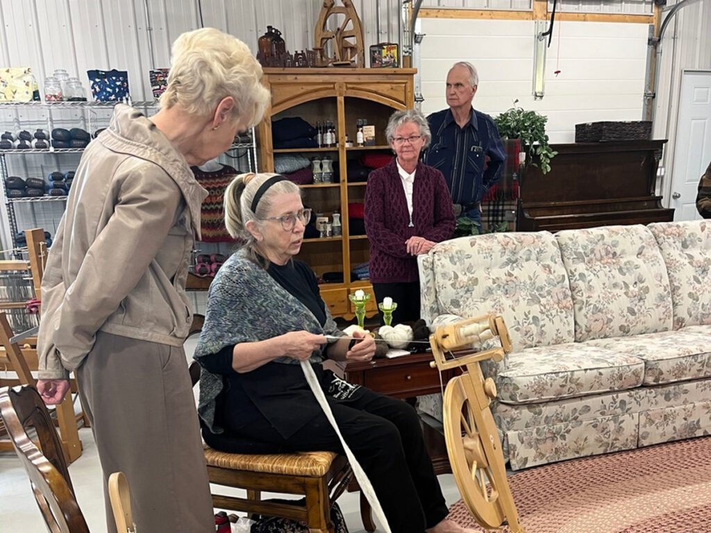 Peggy Gwillim spins yarn at the Canadian Fibre Mill near Caron, Sask., while Lt.-Gov. Bernadette McIntyre, left, and mill owners Karen and Howard Smith watch.