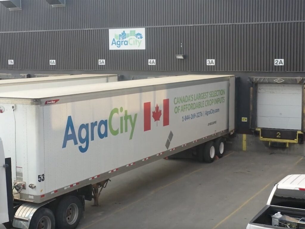 A semi trailer belonging to AgraCity is backed up to the loading dock at an AgraCity warehouse.