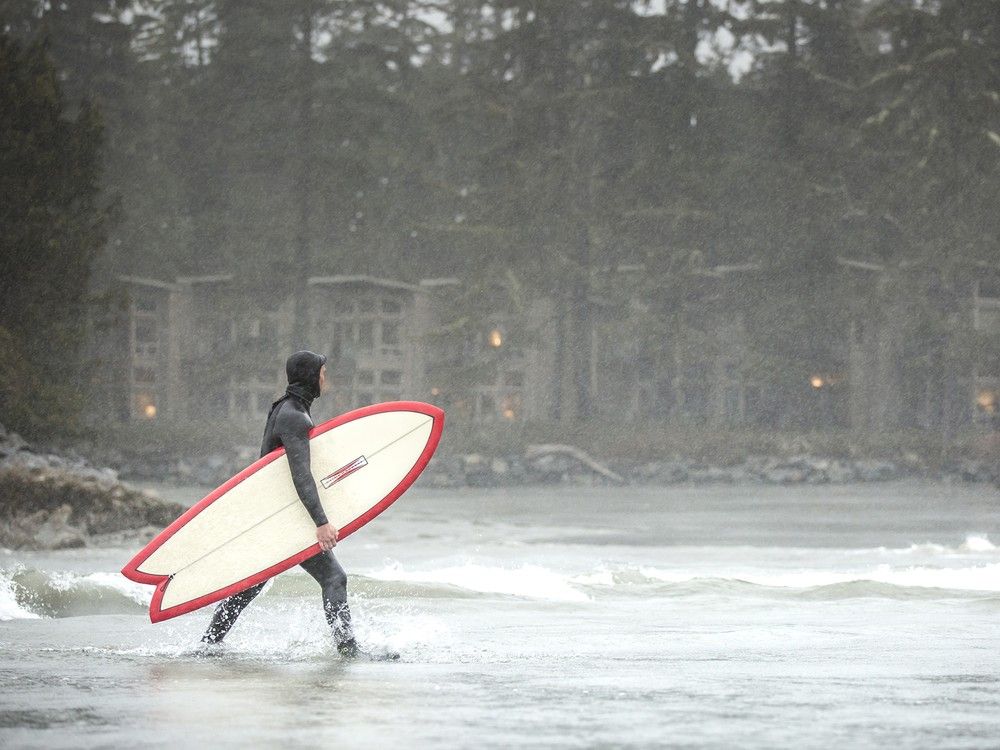 A surfer takes to the ocean near Tofino.