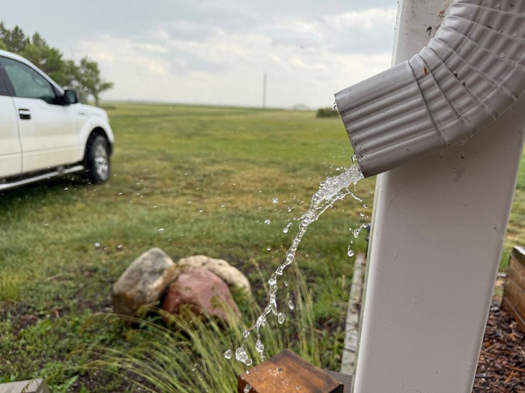 Water spills from a downspout on a home southeast of Delisle, Saskatchewan.