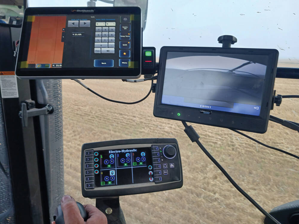 A modern tractor cab showing multiple screens displaying reams of data.