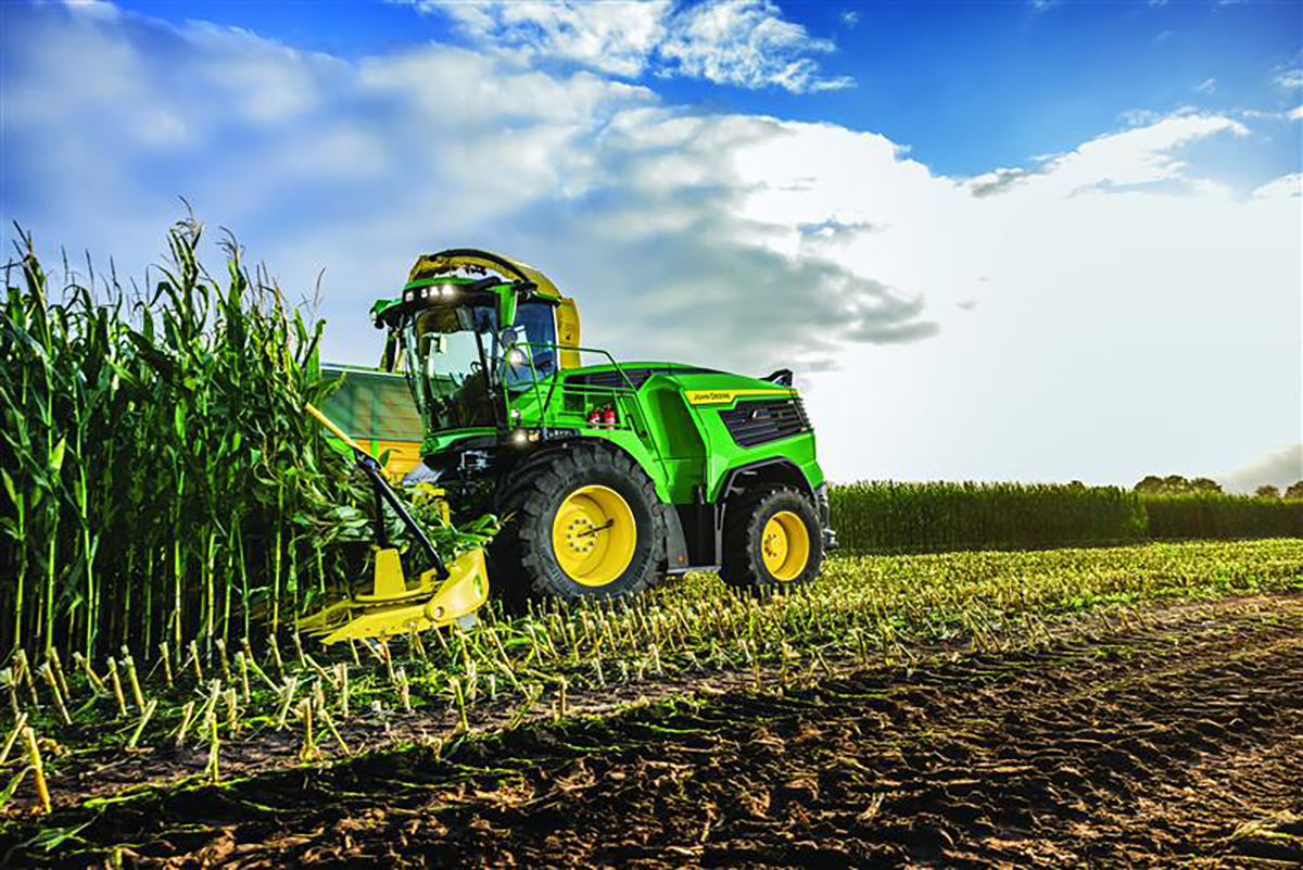A new John Deere forage harvester mows down a corn crop.
