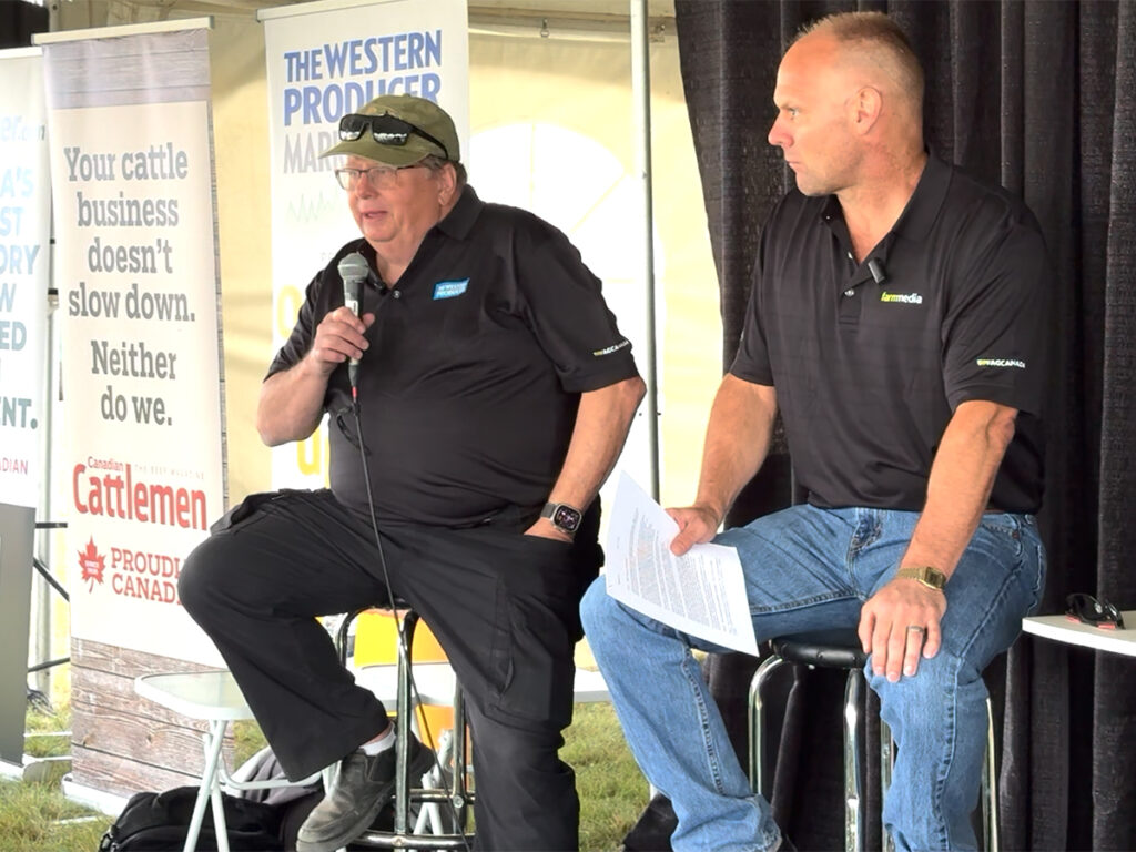 Bruce Burnett, left, and Jerry Klassen talk markets at the Ag in Motion farm show near Langham, Sask.