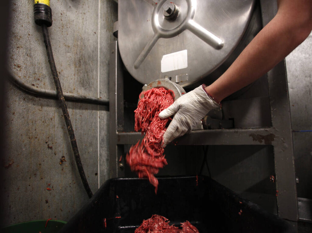 Butcher Brett Marley holds freshly ground beef at Casey