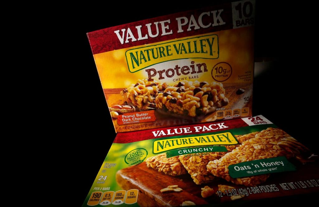 Two boxes of Nature Valley bars, one containing protein and one without, are seen in this photo illustration in Wilmette, Illinois, September 12, 2014. Protein has so far scored a big win for companies which are looking for new ways to beef up their profits as sales of traditional prepared foods slip and consumers seek healthier and fresher food options. General Mills, which Wednesday reported lower-than-expected quarterly profit, is counting on its protein-fortified snacks and expanded Yoplait Greek yogurt line to boost profits. Its Nature Valley protein bars, introduced in 2012, made over $100 million in sales in their first year. To match analysis USA-RETAIL/PROTEIN REUTERS/Jim Young (UNITED STATES - Tags: BUSINESS FOOD HEALTH)