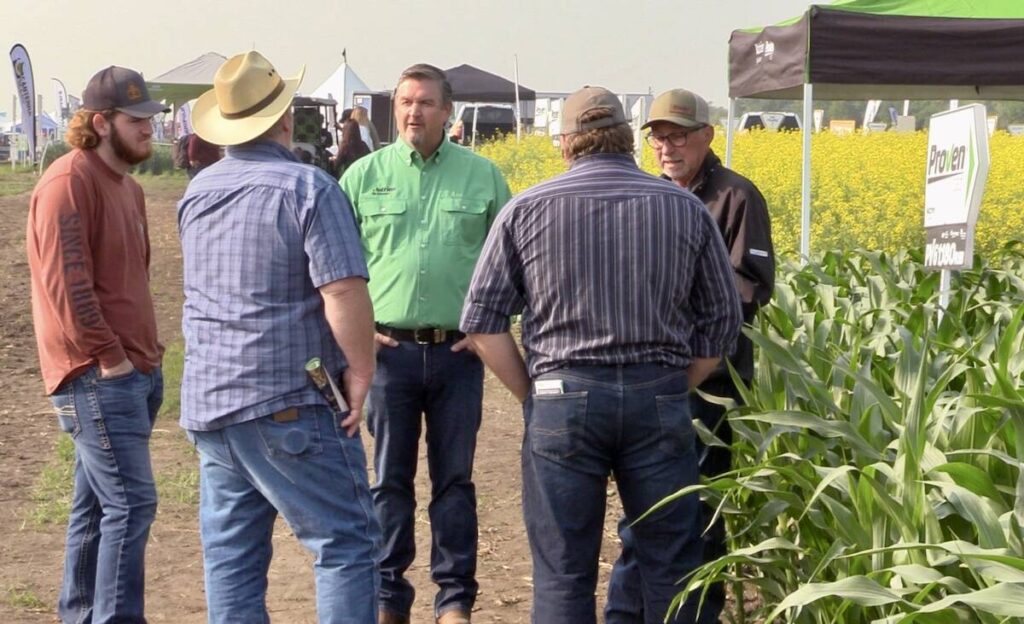 Spencer Harris (green shirt) speaks with attendees at the Nutrien Ag Solutions crop plots at Ag in Motion on July 16, 2025. Photo: Greg Berg