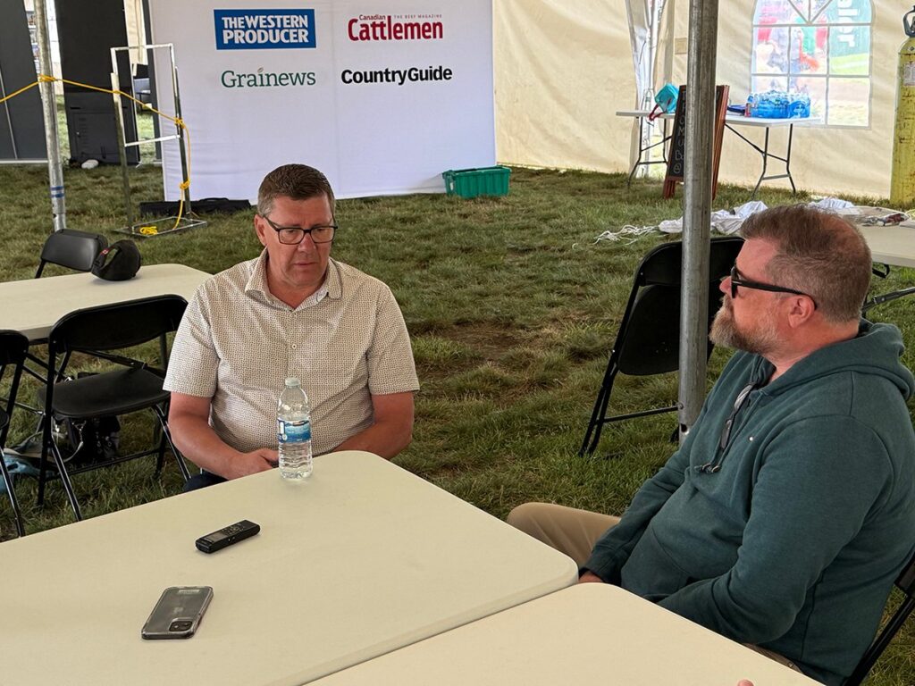 Scott Moe, left, talks to Western Producer reporter Sean Pratt at the Ag in Motion farm show near Langham, Saskatchewan.