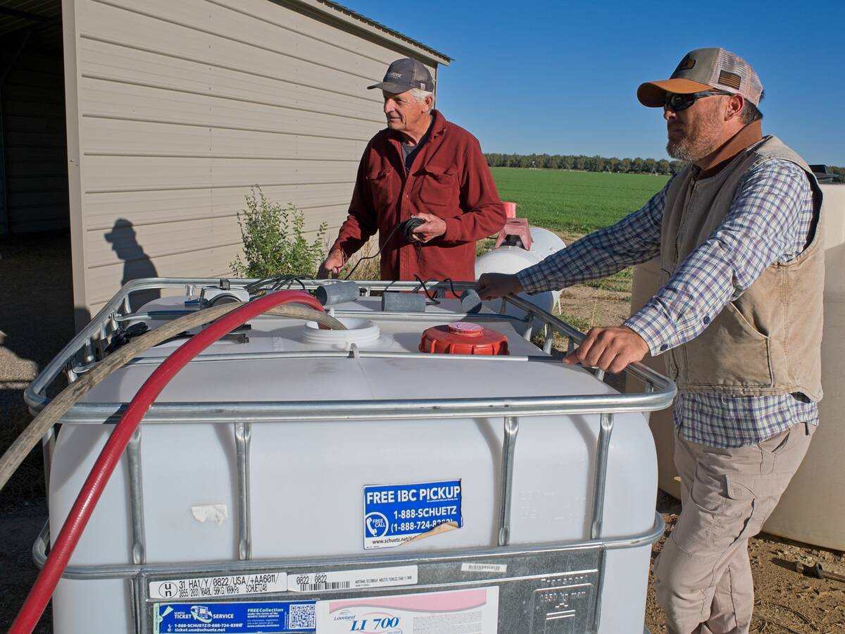 Elson Shields (left) with a one of the crop consultants his company works with, next to a tank filled with nematodes.