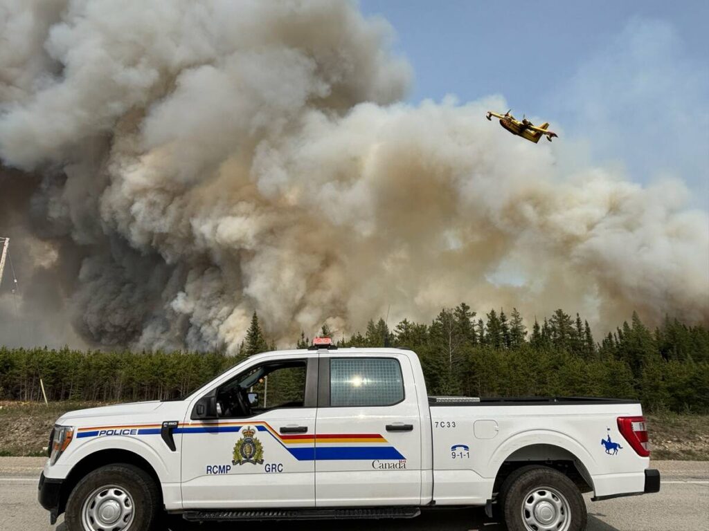 Smoke rises out of a northern Manitoba fire in late May 2025. A water bomber can be seen in the background.