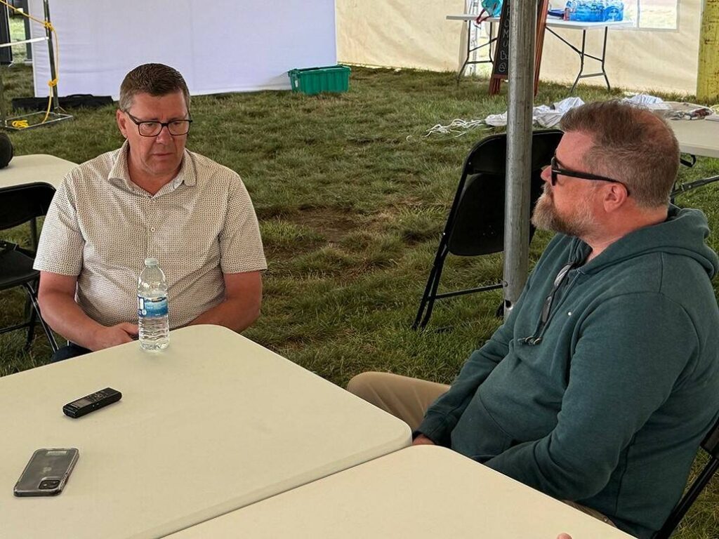 Scott Moe, left, talks to Western Producer reporter Sean Pratt at the Ag in Motion farm show near Langham, Saskatchewan. Photo: Paul Yanko 