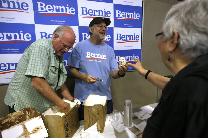 FILE - Ben & Jerry's co-founder Ben Cohen, left, and fellow co-founder Jerry Greenfield, centre, scoop ice cream before a campaign event for Sen. Bernie Sanders, I-Vt., not shown, Sept. 1, 2019, in Raymond, N.H. (AP Photo/Steven Senne, File)