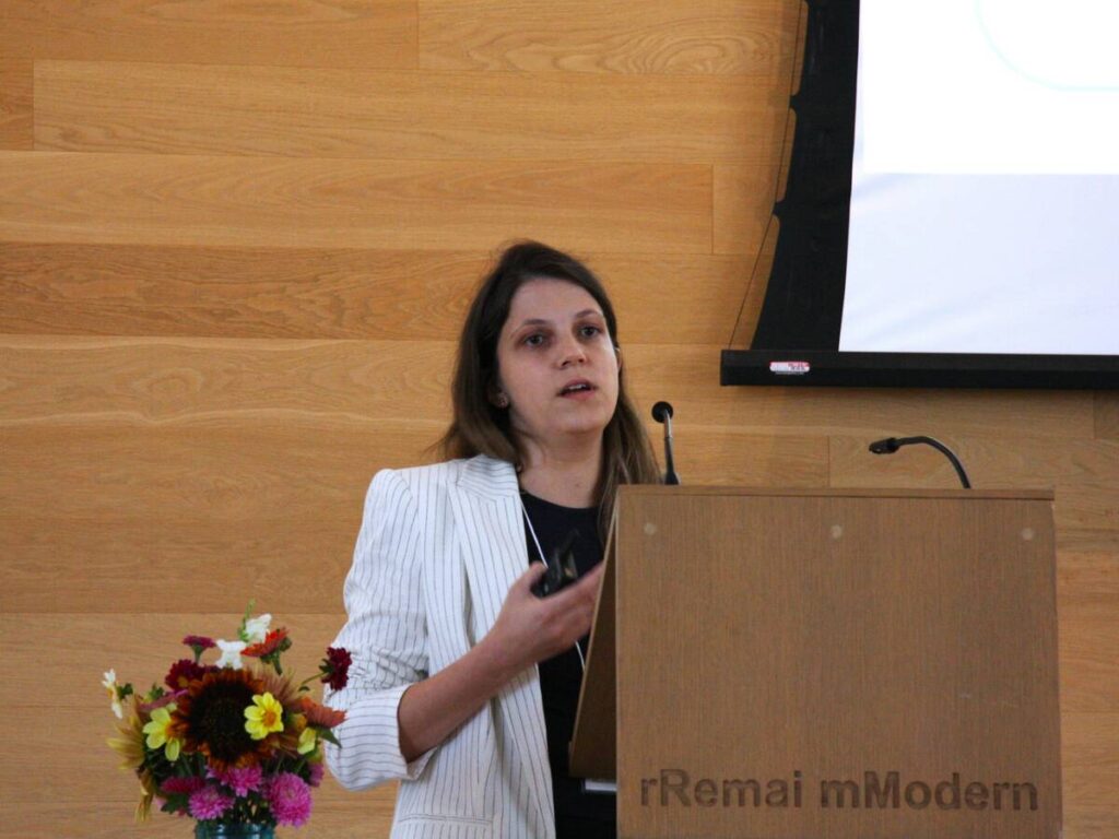 Sheila Andrade, a University of Saskatchewan PhD student, stands at a podium presenting her research.