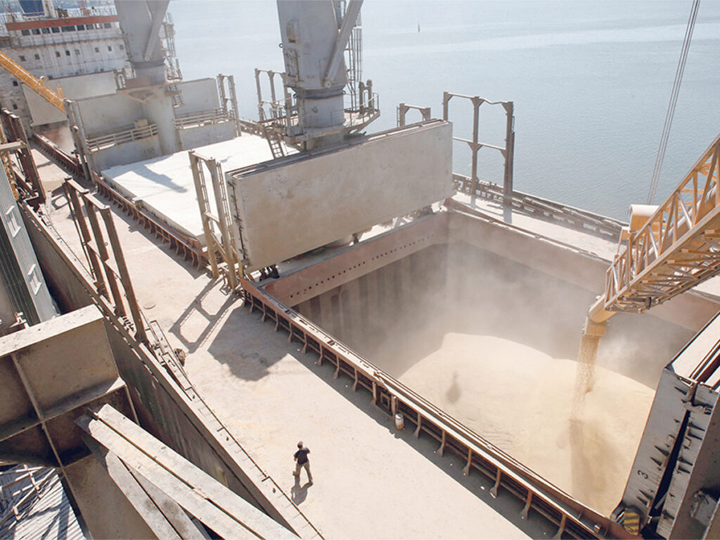 A large bulk container ship is being loaded with grain.