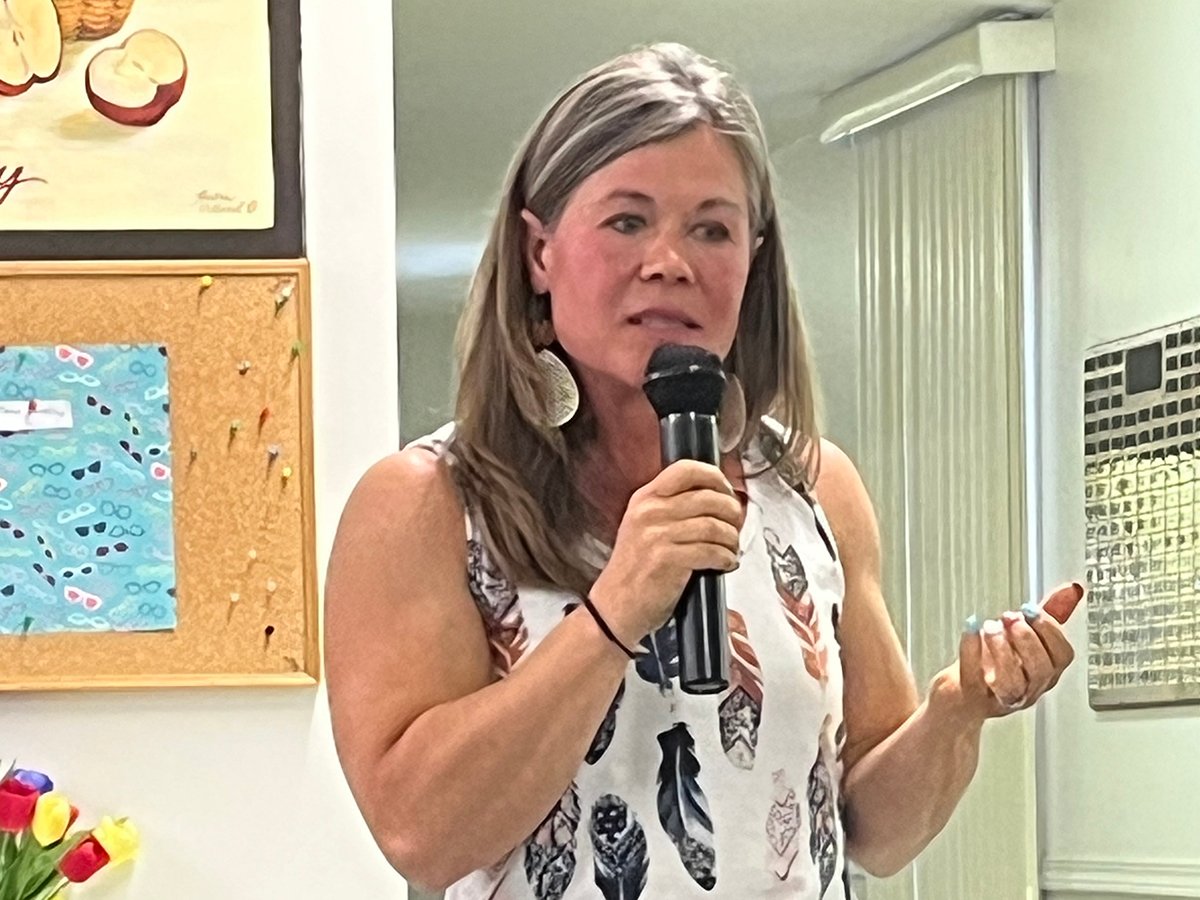 Kim Davis speaks into a microphone at a meeting of the Oldman Lease Holders Association in Vauxhall, Alberta.