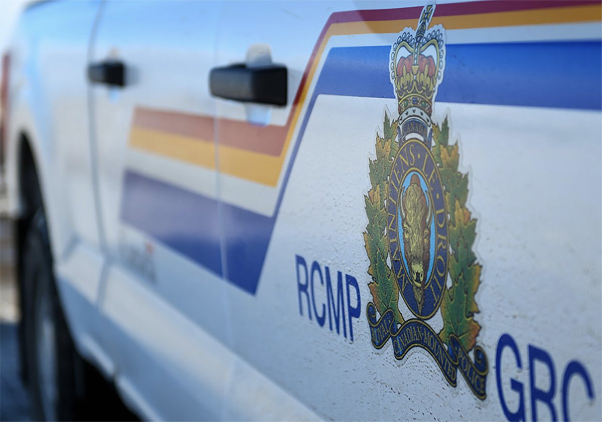 A close-up of the door of a white police vehicle featuring the logo and blue, red and yellow striping of the Royal Canadian Mounted Police.
