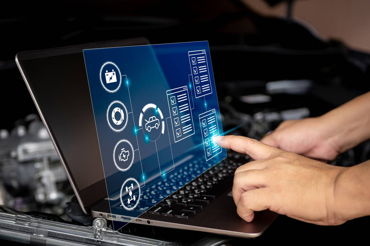 A man's hands are on the keyboard of a laptop and its screen is folded up beyond vertical and a hologram is being projected between the laptop's screen and keyboard which one of the hands on the keyboard is poking to select something with its index finger.