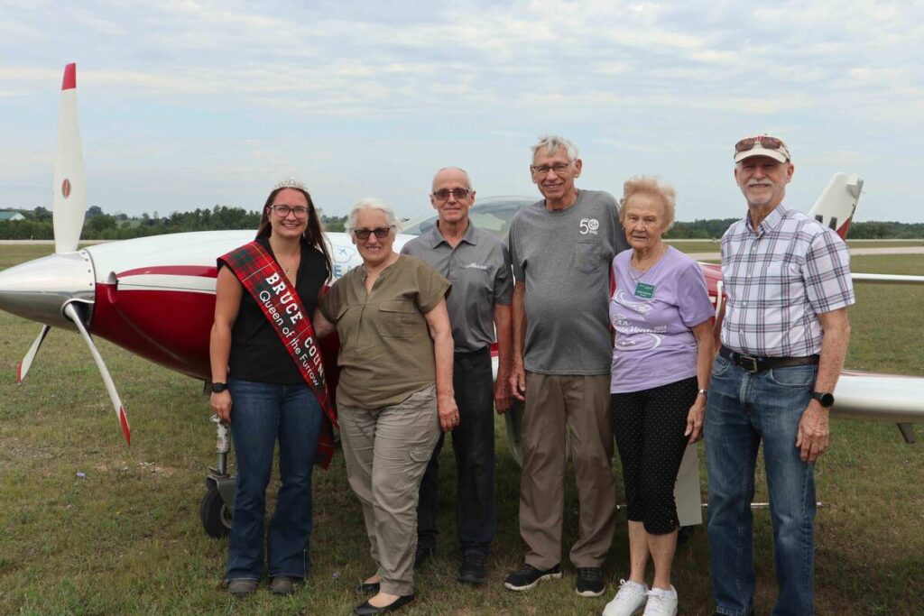 Members of the International Flying Farmers, Ontario Chapter were recently joined by Bruce County Queen of the Furrow Jasmin Schiestel at a meet up at the Saugeen Municipal Airport near Walkerton, Ontario. The group hosts regular fly-ins across the province featuring guests, fundraisers and learning events. Pictured: Bruce Country Queen of the Furrow Jasmin Schiestel, Maria Hodgins, Burt Hodgins, Fred Bruinsma, Marilyn Bruinsma and Don Matheson.
