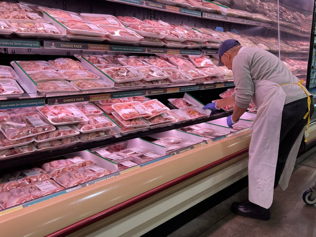 A butcher stocks meat at a grocery store in Mississauga, Ontario.