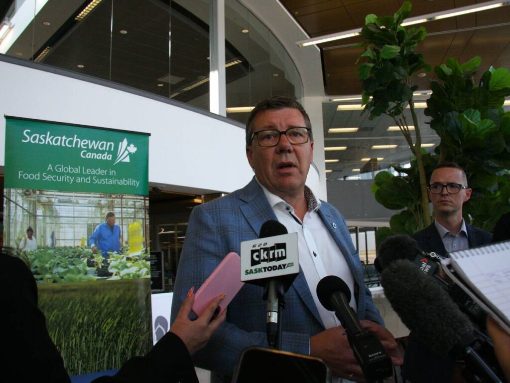 Saskatchewan Premier Scott Moe takes questions from reporters in Saskatoon International Airport.