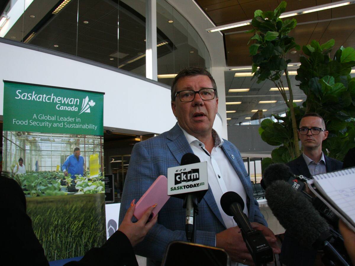 Saskatchewan Premier Scott Moe takes questions from reporters in Saskatoon International Airport.