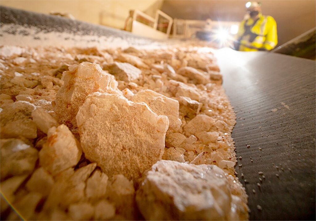 A close-up photo of some potash on an underground conveyor belt in a Mosaic potash mine in Saskatchewan.