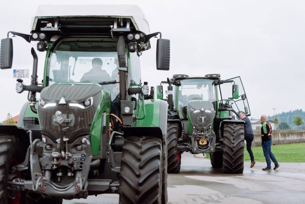 Farmers climb into the cabs of two parked Fendt tractors during a Tech Day held at a farm in Germany at the end of September, 2025.