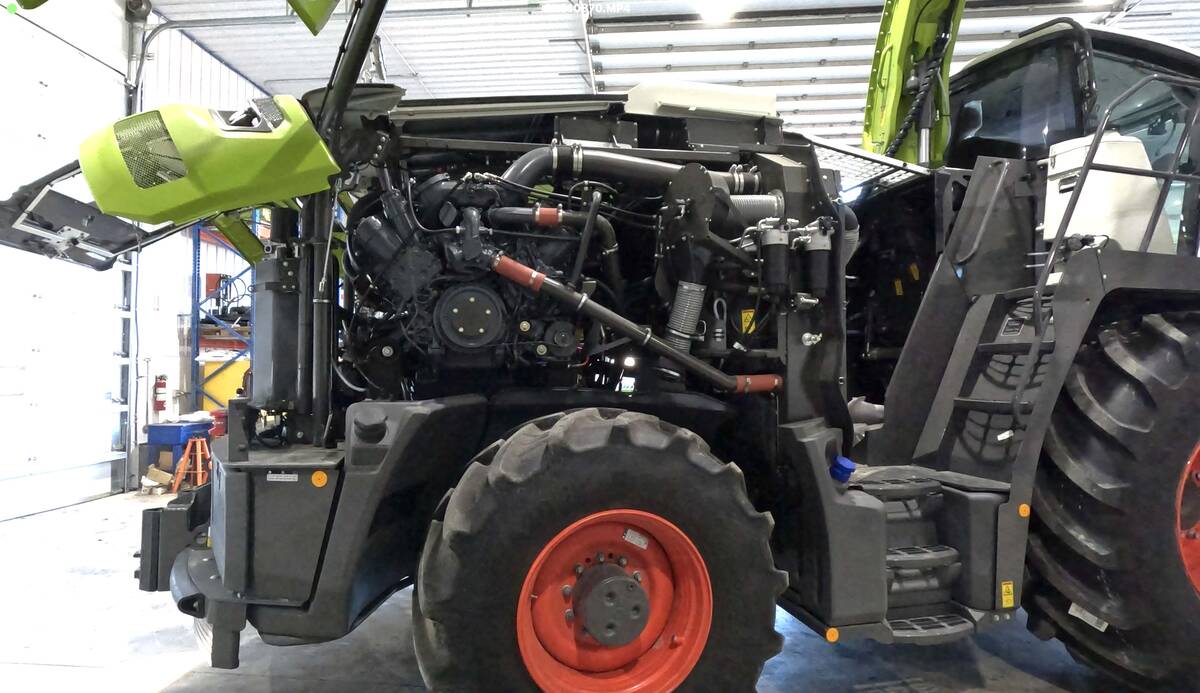 The engine cover is lifted revealing the diesel power plant beneath it on a new Claas forage harvester.