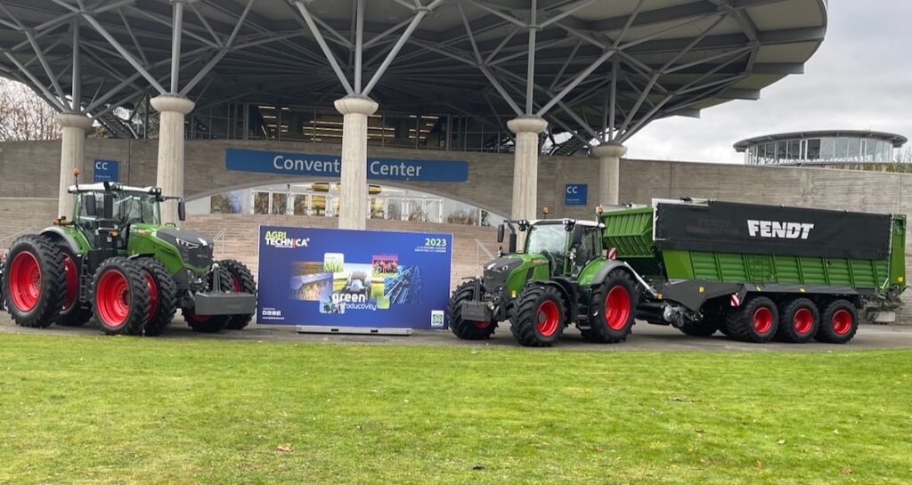 Two Fendt tractors are parked beside an "Agritechnica" sign on the grounds of the world