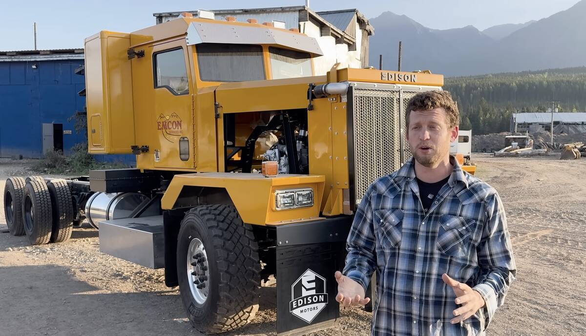Chace Barber, president of Edison Motors, stands beside one of the hybrid diesel-electric trucks built for a road maintenance contractor in British Columbia.