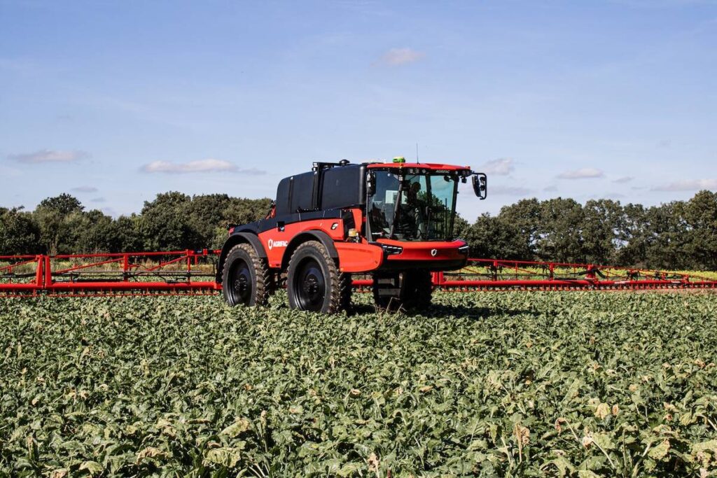A new Agrifac sprayer sits idle in a lush green crop on a sunny day.