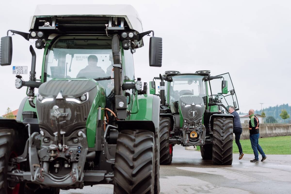 Farmers climb into the cabs of two parked Fendt tractors during a Tech Day held at a farm in Germany at the end of September, 2025.