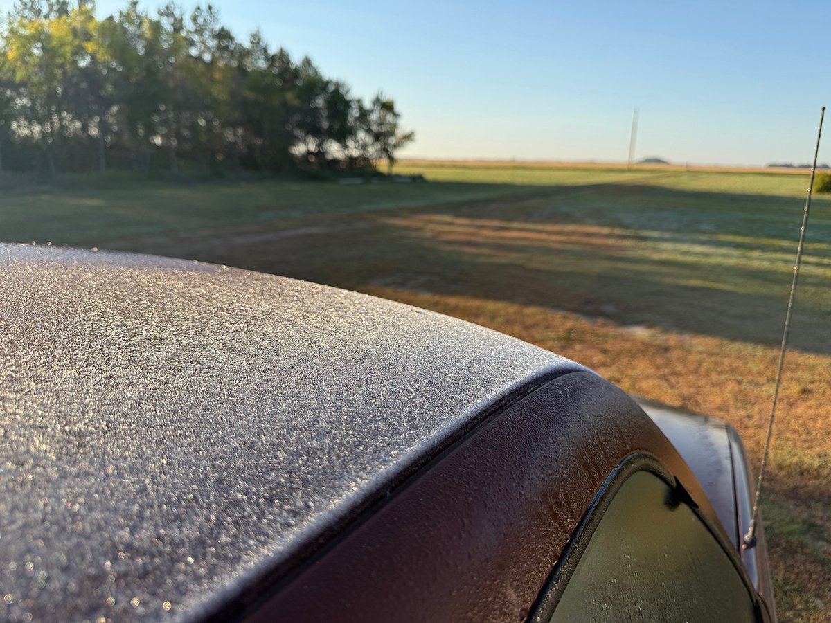 Frost has formed on top of the roof of a red truck.