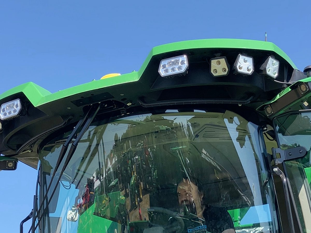 A man sits in the cab of a new John Deere combine on display at Canada's Outdoor Farm Show in Ontario in September, 2025.