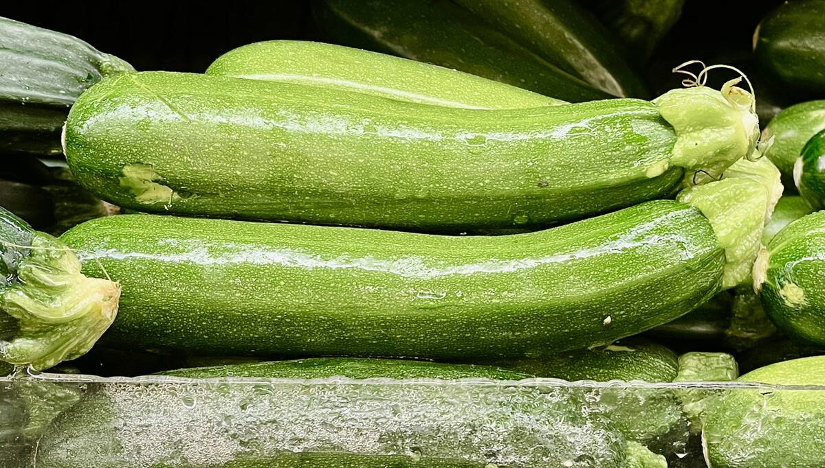 Fresh zucchini stacked in a supermarket display.