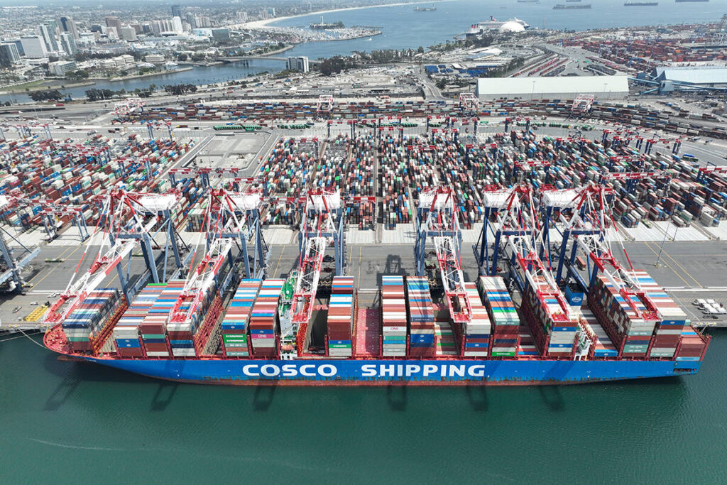 An aerial view of a Cosco shipping container cargo ship at the Port of Long Beach.