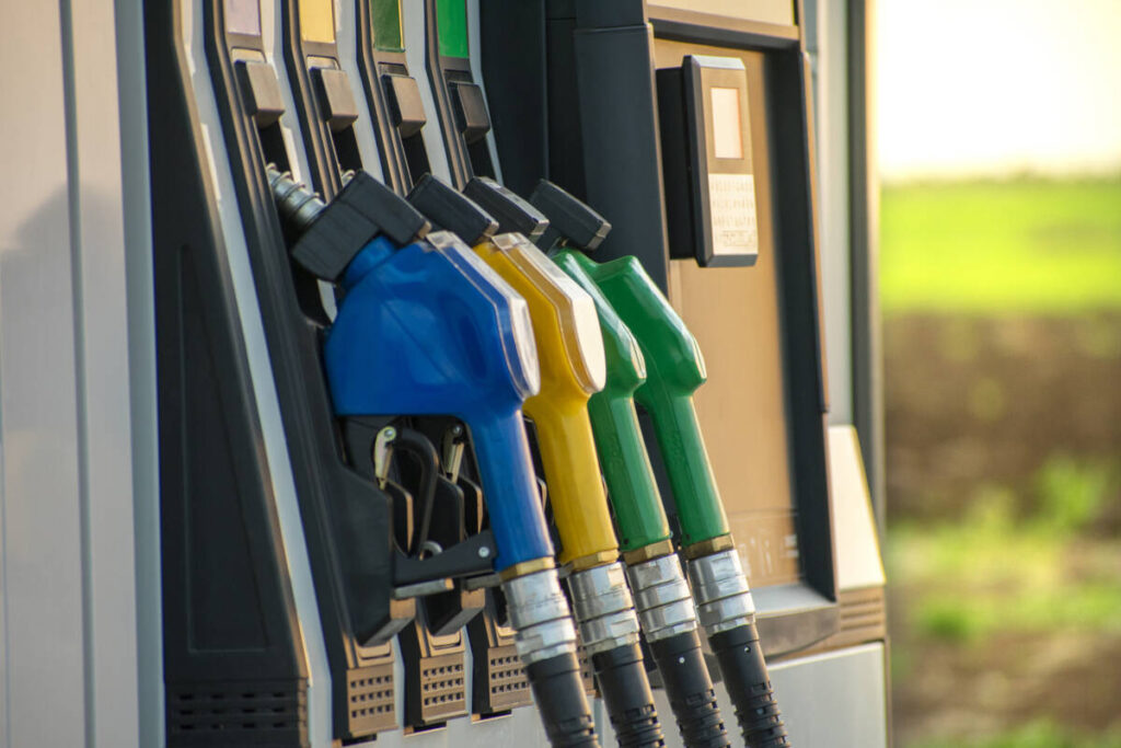 Fuel guns at the fuel station and green field in the background. Photo: Getty Images Plus.