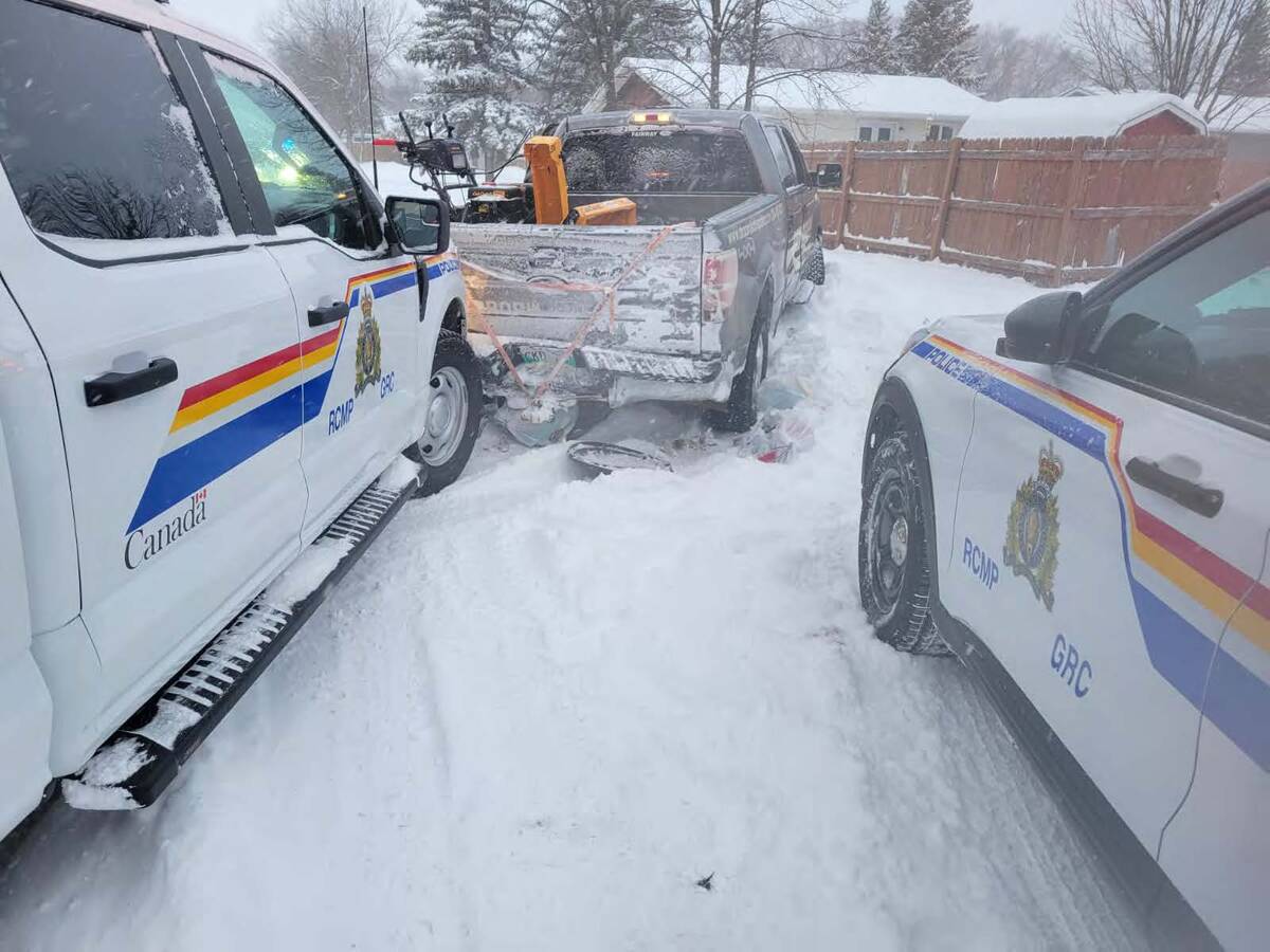 A photo taken from between two police vehicles that have pursued a stolen half-ton truck until it became stuck in snow.